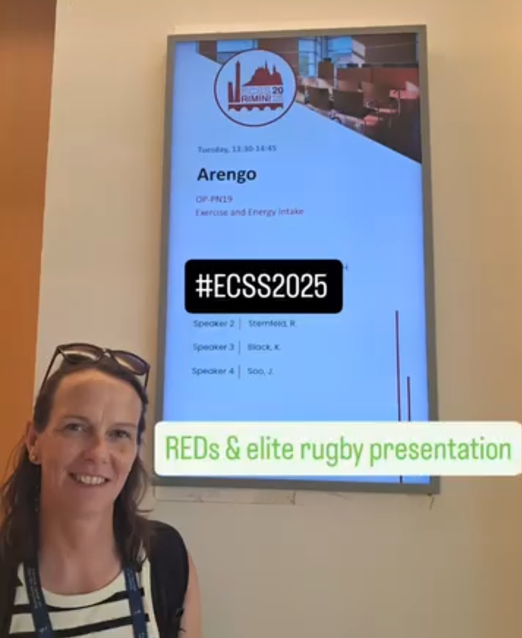 Standing in front of presentation screen at ECSS2025